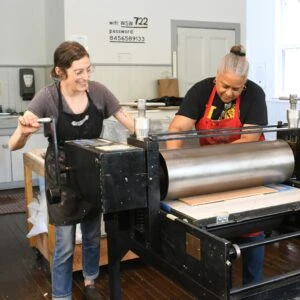 Studio Manager Chris Petrone and artist Laurie Darby working on a print at Women’s Studio Workshop